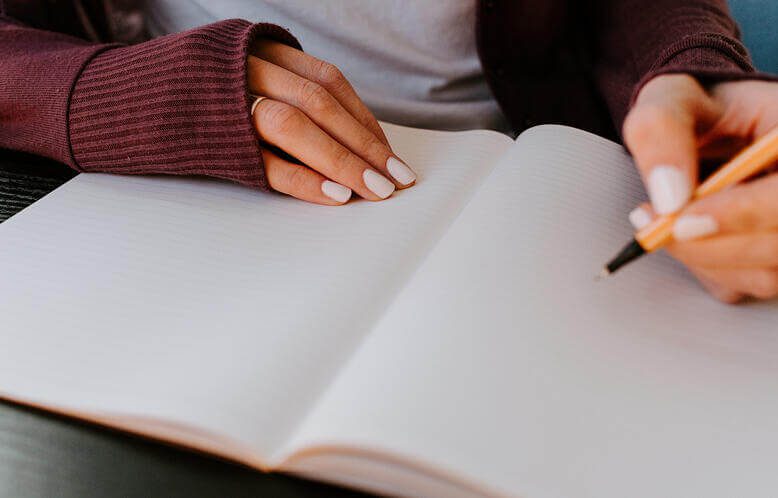 A person writing on a notebook