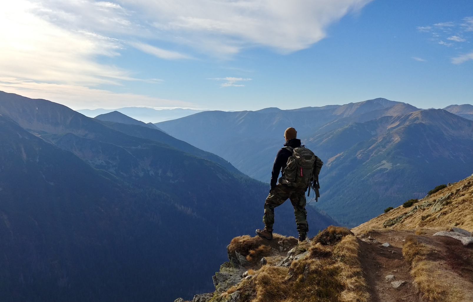 A man looking at the view from the top of a mountain