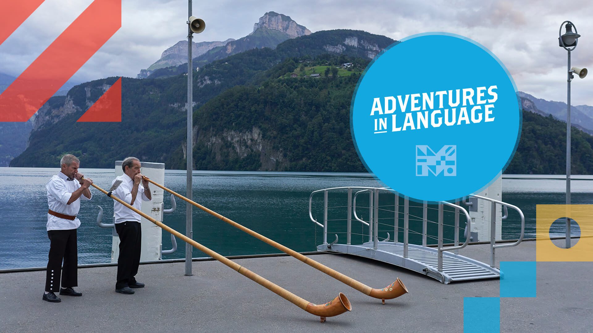 Two men standing on a pier with a mountain landscape behind them. The two men are playing typical Northern European instruments.