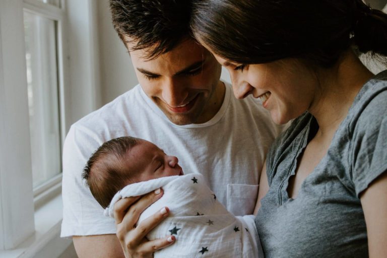 Two parents holding their newborn