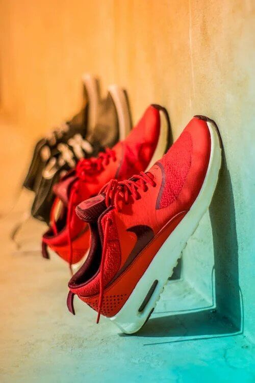 Red sneakers leaning against a wall