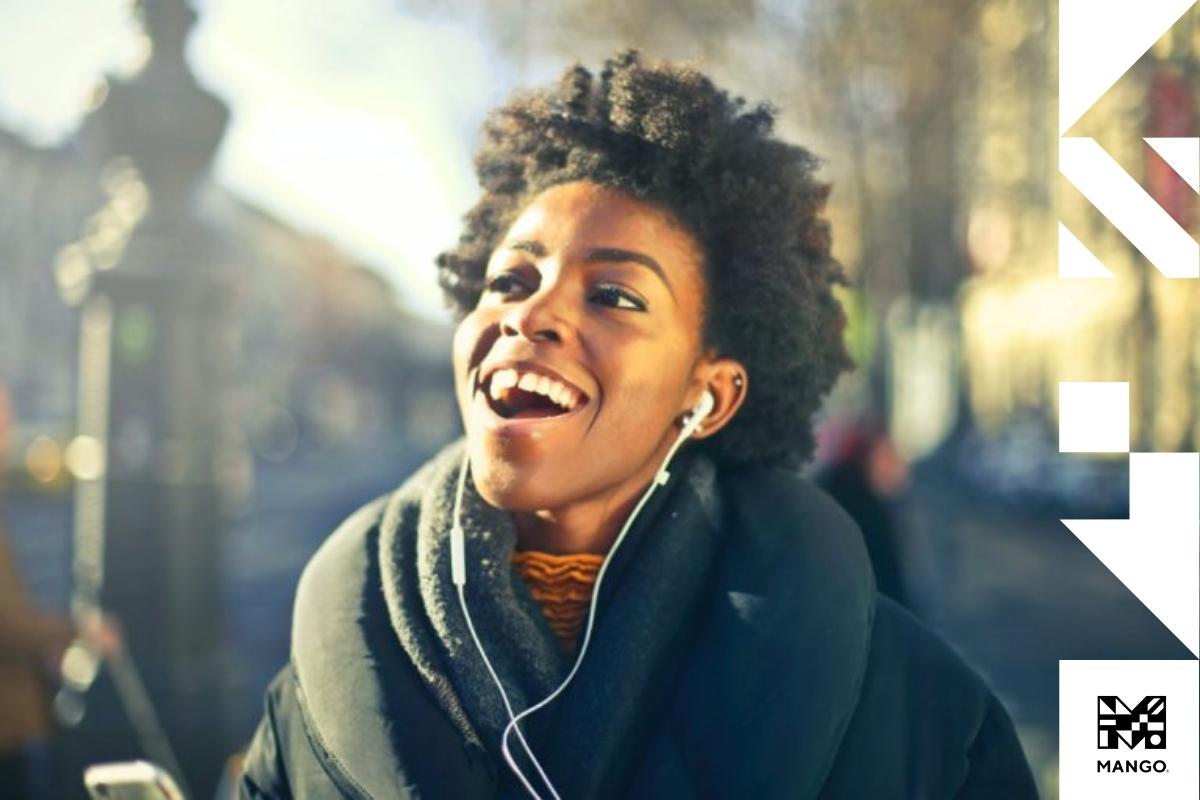 A young woman listening to music while walking down the street