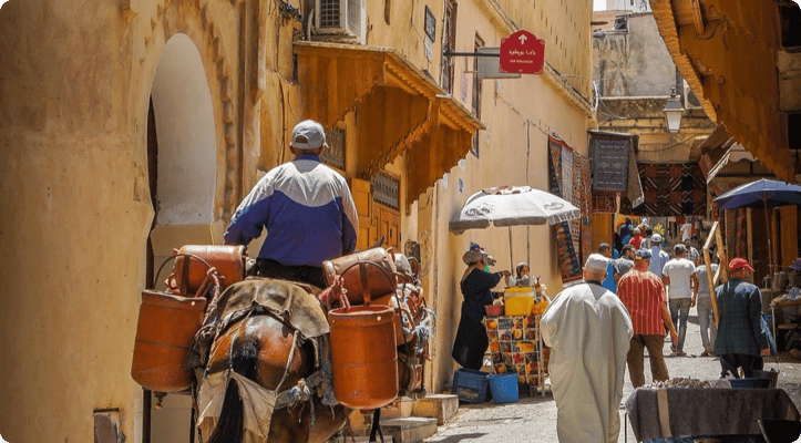 A person riding a horse in a busy street market